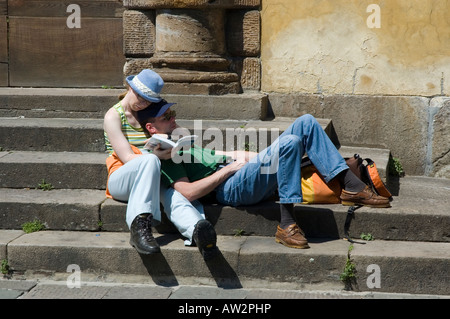 Deux jeunes touristes reste et rattraper le guide book à Lucca dans le Plazza San Martino Banque D'Images