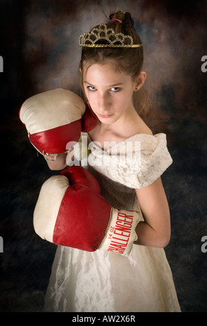 Jeune fille posant en robe avec de la terre et des gants de boxe Banque D'Images