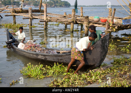 Bateau de pêche pêcheurs poussant sur une plage, fort Cochin, Cochin, Kerala, Inde Banque D'Images