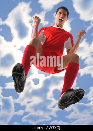 Jeune joueur de football criant avec les yeux fermés et les poings serrés Low angle view Banque D'Images