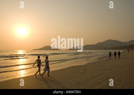 Les gens qui marchent le long de la plage de Palolem à Goa en Inde du Sud au coucher du soleil Banque D'Images