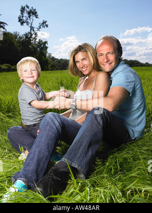 Famille profiter d'une bonne heure dans un champ. Banque D'Images