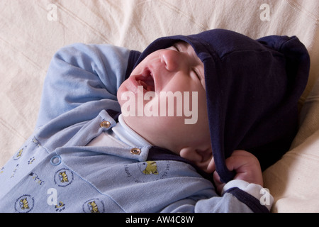 Petit bébé en bleu babygro crier fort Banque D'Images