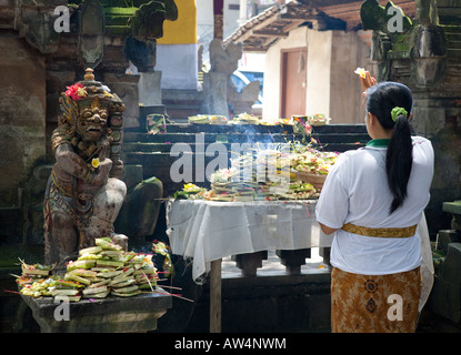 Femme en prière dans un temple hindou de culte à Ubud Bali Indonésie Banque D'Images