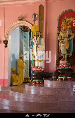 Deux des trois divines se tenir dans la partie arrière de la GRAND TEMPLE DE CAO DAI VILLAGE TAY NINH VIETNAM Banque D'Images