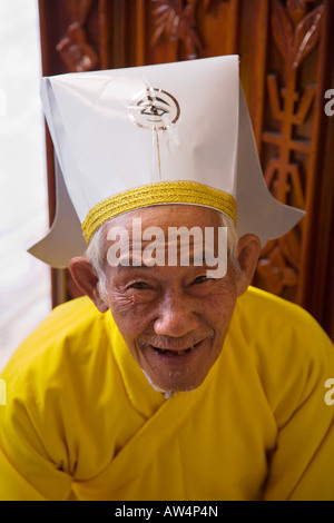 Une personne âgée de clergé CAO DAI qui pose pour un portrait à l'intérieur du grand temple de CAO DAI VILLAGE TAY NINH VIETNAM Banque D'Images