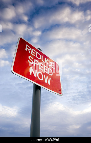 Réduire la vitesse maintenant roadsign contre un ciel magnifique Banque D'Images