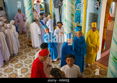 Taoïste et Bouddhiste d'adorateurs se rassemblent dans le chrétien avant du Grand Temple de CAO DAI VILLAGE TAY NINH VIETNAM Banque D'Images