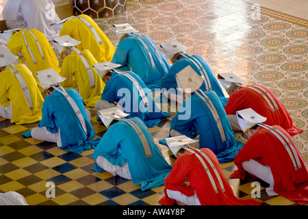 Taoïste et Bouddhiste, les membres du clergé chrétien prier lors d'une cérémonie à l'intérieur du grand temple de CAO DAI VILLAGE TAY NINH VIETNAM Banque D'Images