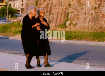 Deux personnes âgées femmes grecques, vêtus de noir en prenant une promenade en soirée, la Crète, les îles Grecques Banque D'Images