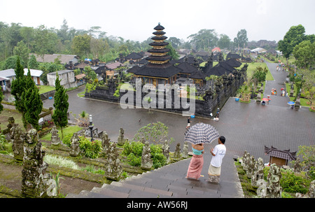 Les touristes portant des parapluies escalade les escaliers jusqu'à la Pura Besakih Temple Bali Indonesia Banque D'Images