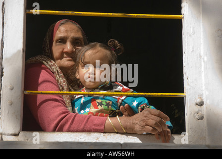 Portrait d'une grand-mère et sa petite-fille et contempler l'enfant d'une fenêtre à Jaipur, Inde. Banque D'Images