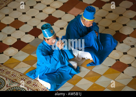 Les membres du clergé taoïste prier lors d'une cérémonie à l'intérieur du grand temple de CAO DAI VILLAGE TAY NINH VIETNAM Banque D'Images