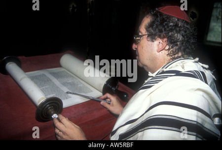 Judaïsme : un rabbin qui lit le défilement de la torah dans la synagogue de l'ouest de Londres. Banque D'Images