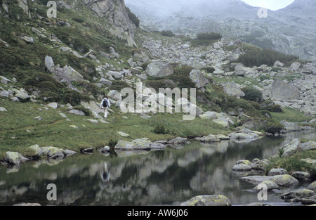 Voyageur seul dans Valjavishko Rocky Lake dans le parc national de Pirin Bulgarie Banque D'Images