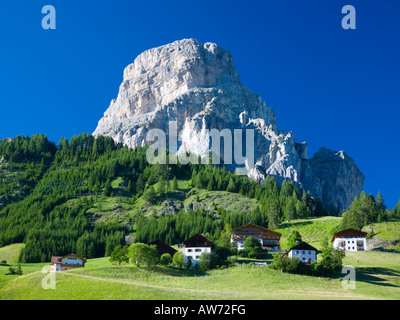 Corvara, Val Badia, Trentino-Alto Adige, Italie. Chalets sur la colline verdoyante sous le pic de Sassongher. Banque D'Images