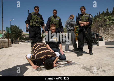 Les membres des forces de sécurité israéliennes sont en garde tandis que les Palestiniens prient à Jérusalem-est Israël Banque D'Images