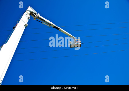 Les travailleurs de service de maintenance travaillant sur la ligne d'alimentation électrique hydro à partir d'une grue Banque D'Images