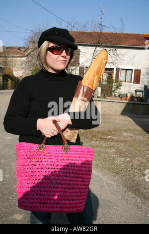 Femme française de quitter la boulangerie ou boulangerie avec une baguette Banque D'Images