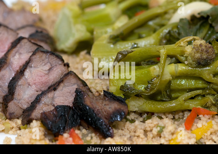 Le filet d'agneau et de brocoli pourpre sur un lit de couscous Banque D'Images