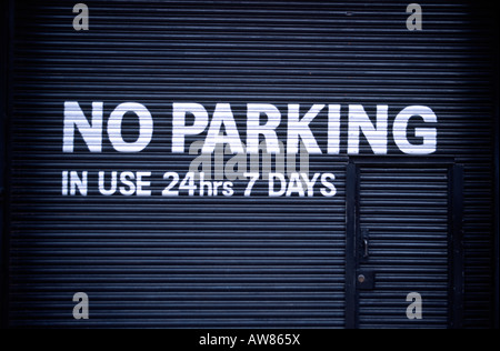 No parking sign sur une porte de garage au Royaume-Uni en service 24 heures par jour Banque D'Images