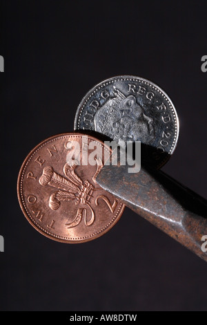 La monnaie britannique 2p et 10p pence coin lieu squeeze par pince à sertir Banque D'Images