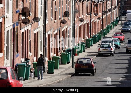 Une rangée de poubelles vertes en attente d'être recueillies sur un trottoir à Nottingham, Royaume-Uni Banque D'Images
