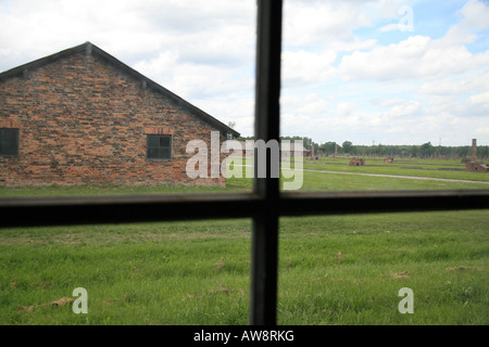 Une vue de la fenêtre d'un édifice en brique sur l'ancien camp de concentration Nazi à Auschwitz Birkenau, Oswiecim, Pologne. Banque D'Images