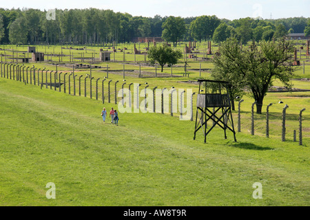 Les visiteurs de marcher à côté des blocs en ruine à l'ancien camp de concentration Nazi à Auschwitz Birkenau, en Pologne. Banque D'Images