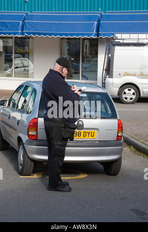 Gwynedd au nord du Pays de Galles UK préposé au stationnement écrit ticket de parking pour voiture stationnée illégalement dans un parking à mobilité bay Banque D'Images