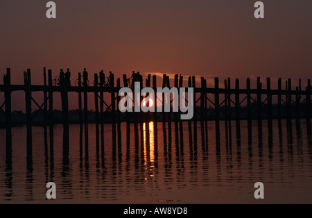 Les moines et les villageois à la maison au coucher du soleil sur le pont de U Bein, Amarapura, Myanmar (Birmanie) Banque D'Images