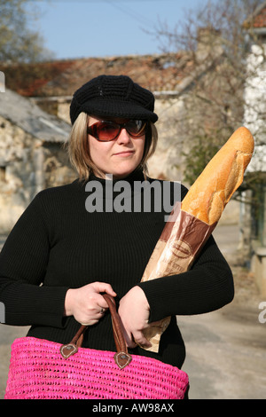 Femme française de quitter la boulangerie ou boulangerie avec une baguette Banque D'Images