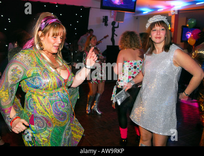 Femmes dans les années 60 et 70 garb et demeanor pendant une soirée rétro dehors, Hounslow, Middlesex, Royaume-Uni. Banque D'Images