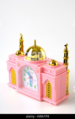 Réveil en plastique rose à la forme d'une mosquée. Tourné sur un fond blanc. Il joue même un jour matin et chant - Azar. Banque D'Images