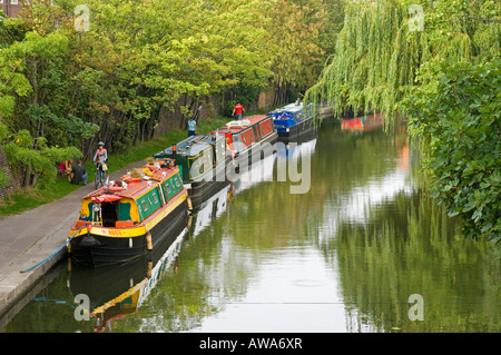 Old fashioned bateaux amarrés le long du Canal Grand Union Canal à Camden avec des gens le long du chemin de halage. Banque D'Images