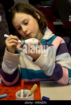 Jeune fille faire de l'art et de l'artisanat projet à l'école avec la poterie et pens Banque D'Images