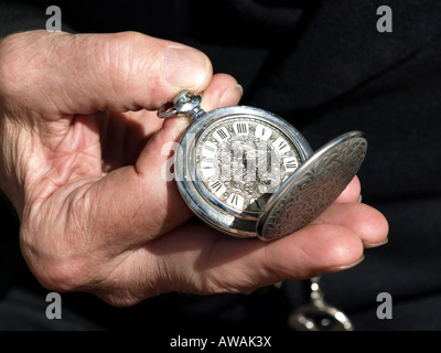 Old watch étant maintenue ouverte pour voir le temps par la main d'un homme Banque D'Images
