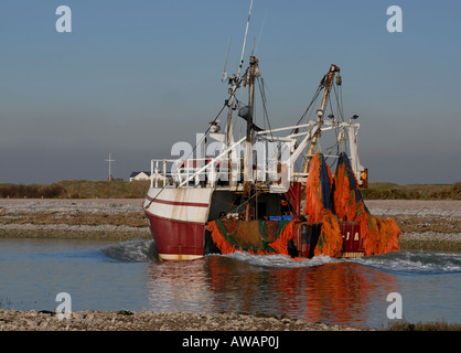 Un bateau de pêche revient à Rye Harbour jusqu'à la rivière Rother Banque D'Images