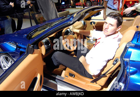 Un journaliste à l'intérieur d'une voiture Ferrari de luxe pendant le Salon International de l'Automobile à Paris, France Banque D'Images