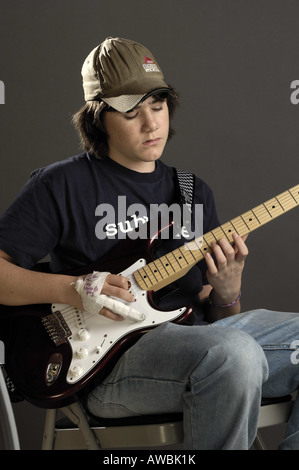 Teenage avec un doigt cassé à la guitare Banque D'Images