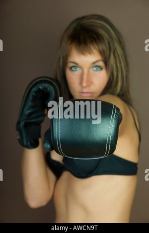 Une femme ayant atteint le port de gants de boxe, les bras étendus Banque D'Images