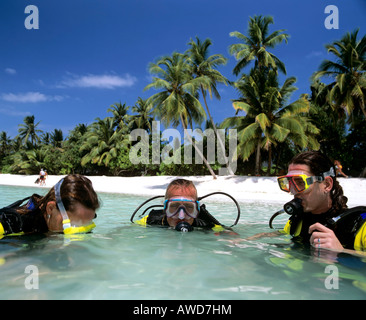 Des leçons de plongée en eaux peu profondes, des palmiers sur la plage, Maldives, océan Indien Banque D'Images