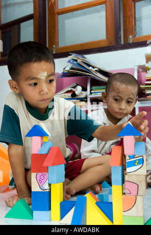Les garçons réfugiés birmans construire un château, Gare de pédiatrie clinique Mae Tao, Maesot, Thaïlande Banque D'Images