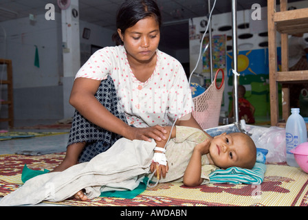 Réfugiés Birmans mère prenant soin de son enfant malade, enfant, clinique Mae Tao, Maesot, Thaïlande Banque D'Images
