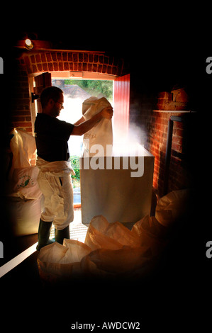 L'orge maltée est versé dans la trémie et vers le bas dans le mash tun,une partie de la fabrication de la bière au processus 1648 Brewing Co. Banque D'Images