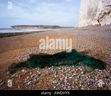 Filet de pêche jeté, échoués sur une plage. Cuckmere Haven, East Sussex, Angleterre, Royaume-Uni. Banque D'Images