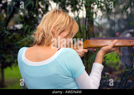 La femme visant avec carabine à air. Banque D'Images