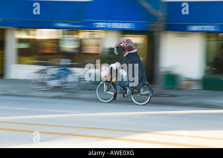 CALIFORNIA Santa Barbara homme habillé en costume d'oiseaux ride bicycle on city street les animaux en peluche dans le panier de guidon Banque D'Images