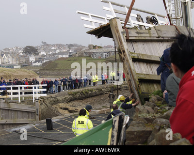 Grande foule de personnes regardant la mer du canal de Bude verrouiller la porte d'être supprimé par crane après avoir été endommagé dans le 10 mars 2008 tempête. Banque D'Images