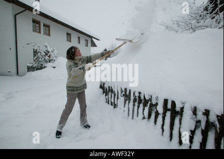 Femme de pelleter de la neige, de Haute-bavière, Bavaria, Germany, Europe Banque D'Images